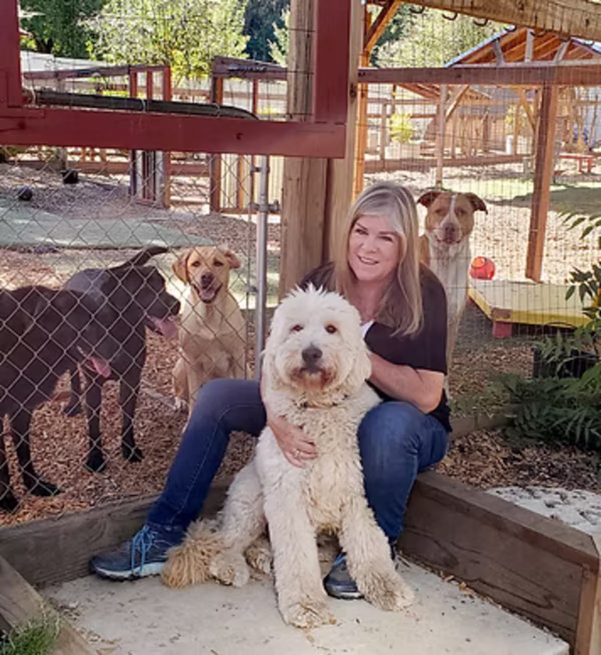Donna sitting outdoors with Zander, her new dog, demonstrating her continued commitment to learning and connecting with dogs
